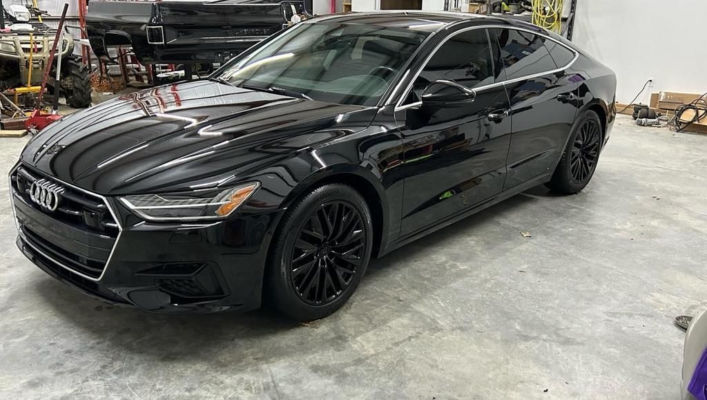 A black audi a7 is parked in a garage.