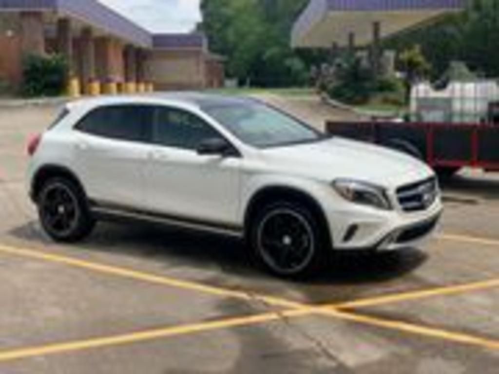A white mercedes benz gla is parked in a parking lot.