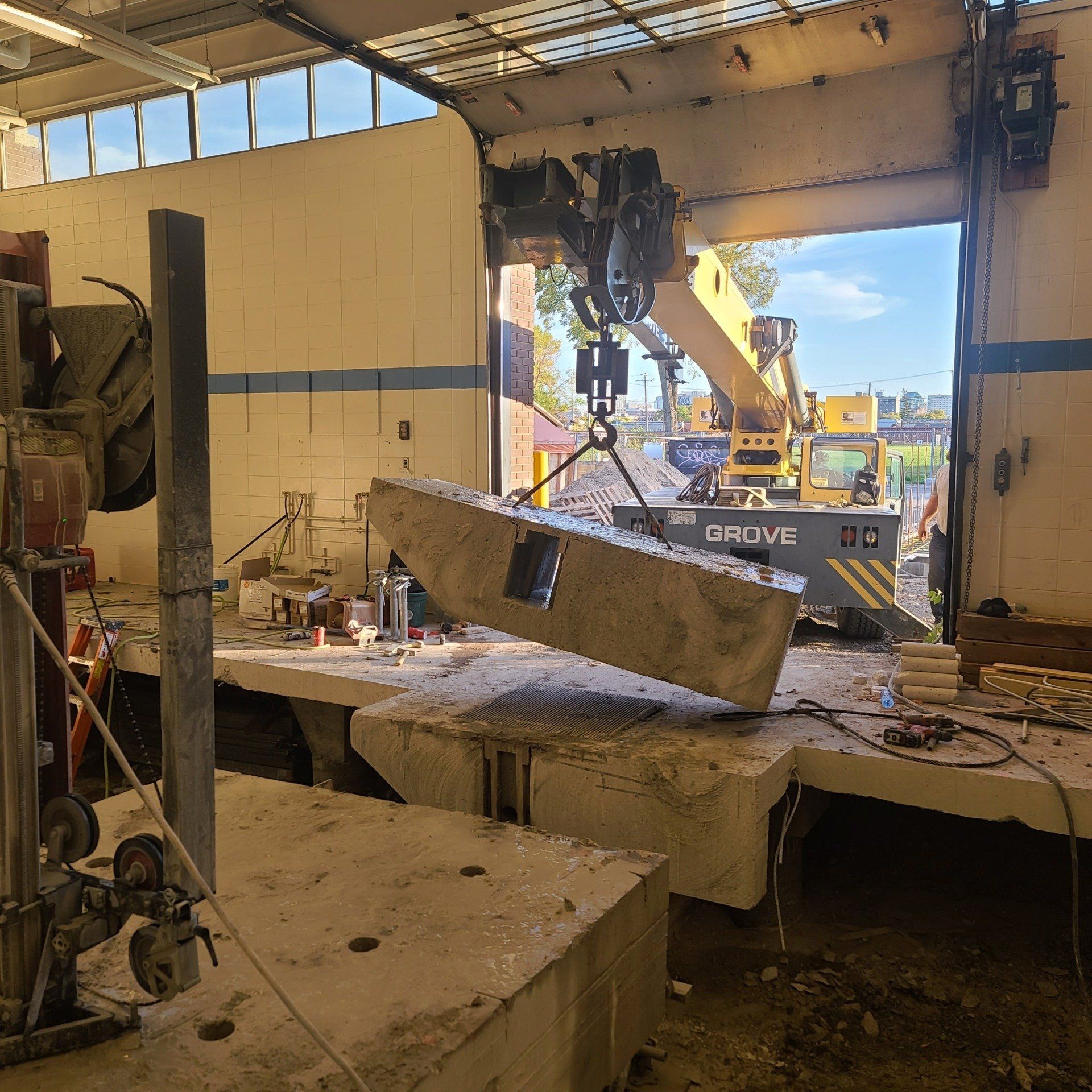 A large piece of concrete is being lifted by a crane that says crave