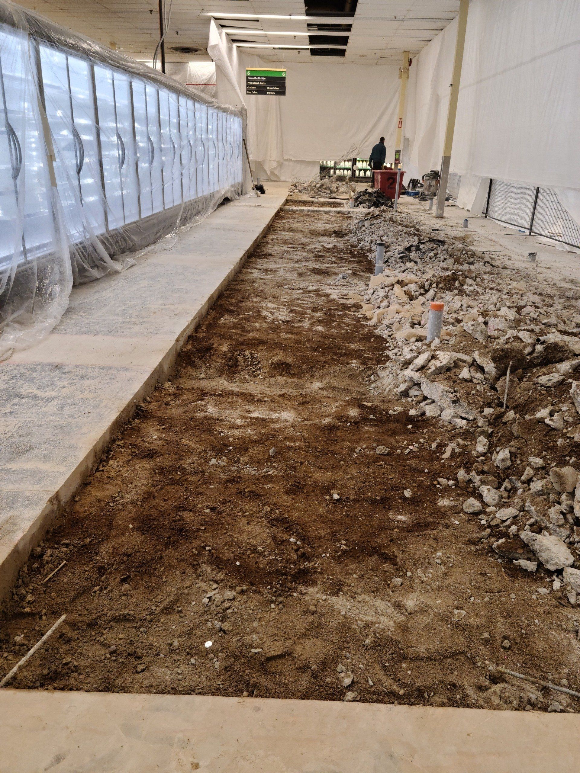 A building under construction with a lot of dirt on the ground.