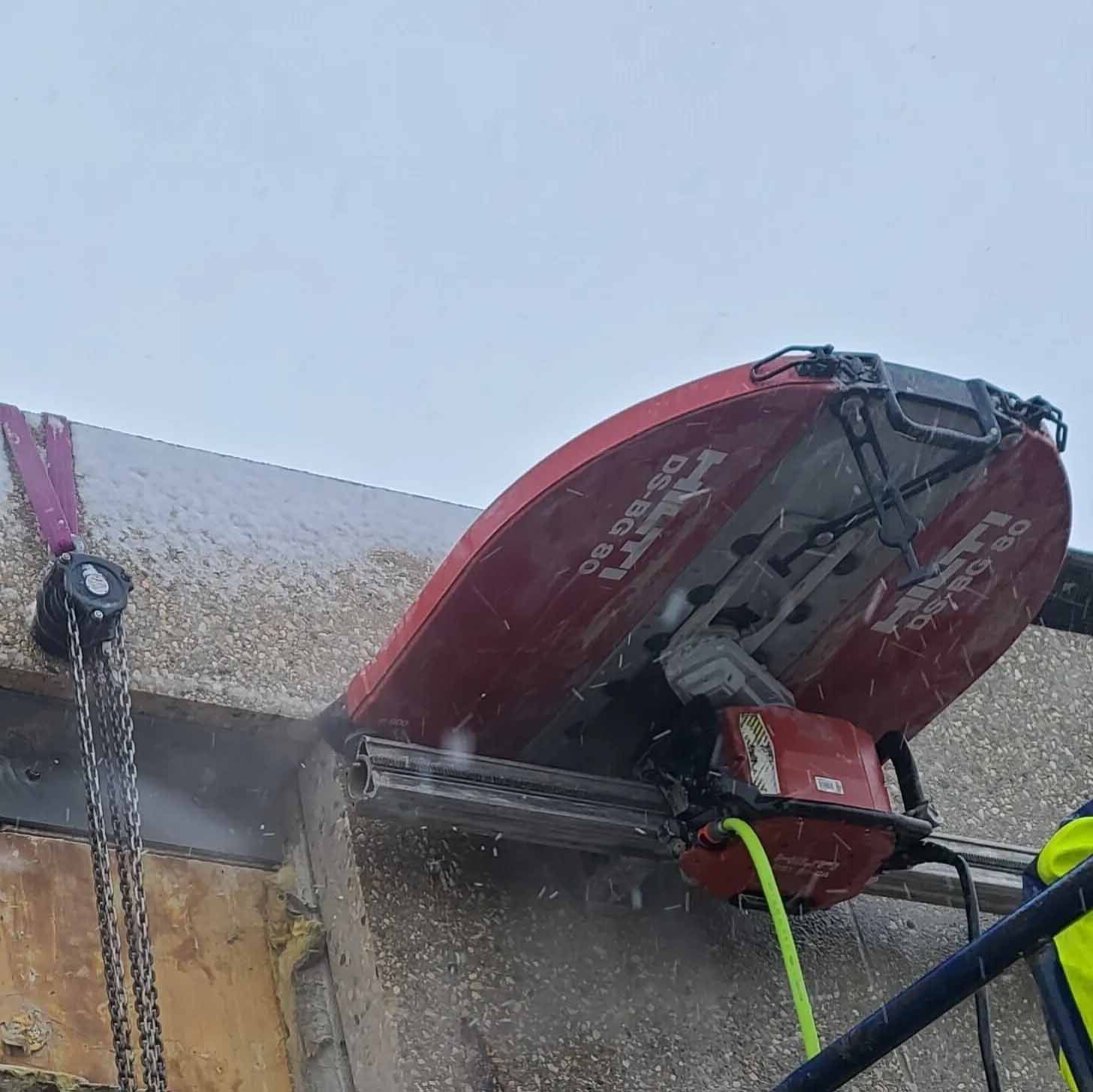 A machine is cutting a hole in a wall.