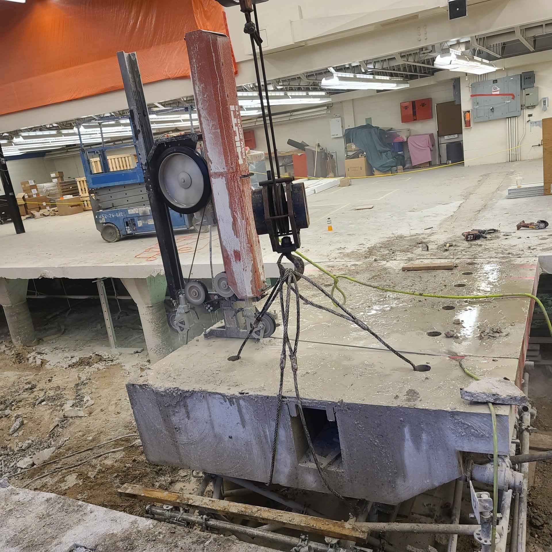 A large piece of concrete is being cut by a machine