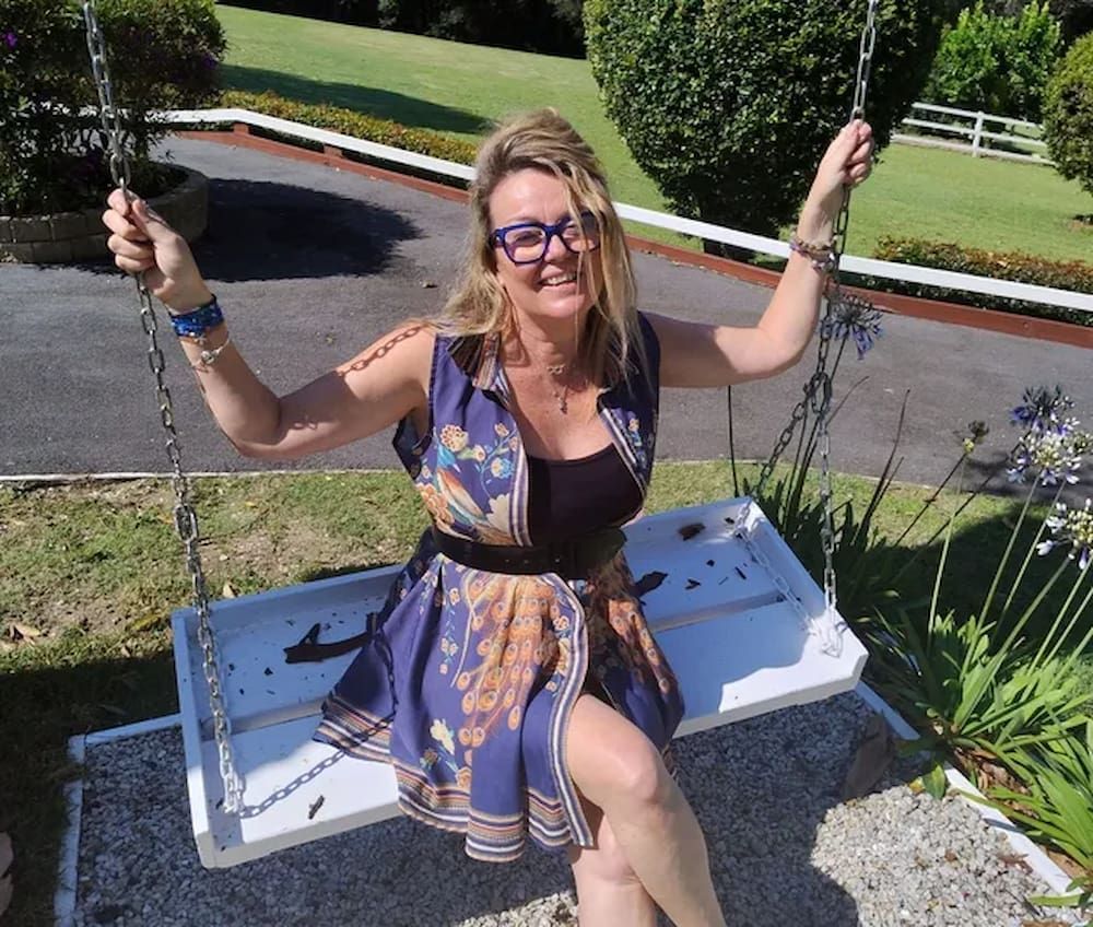 A Woman in a Blue Dress is Sitting on a Swing — Yoni Steam Australia in Gold Coast, QLD