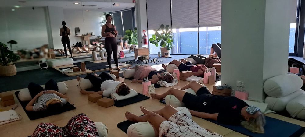 A Group of People Are Laying on Yoga Mats in a Room — Yoni Steam Australua in Gold Coast, QLD