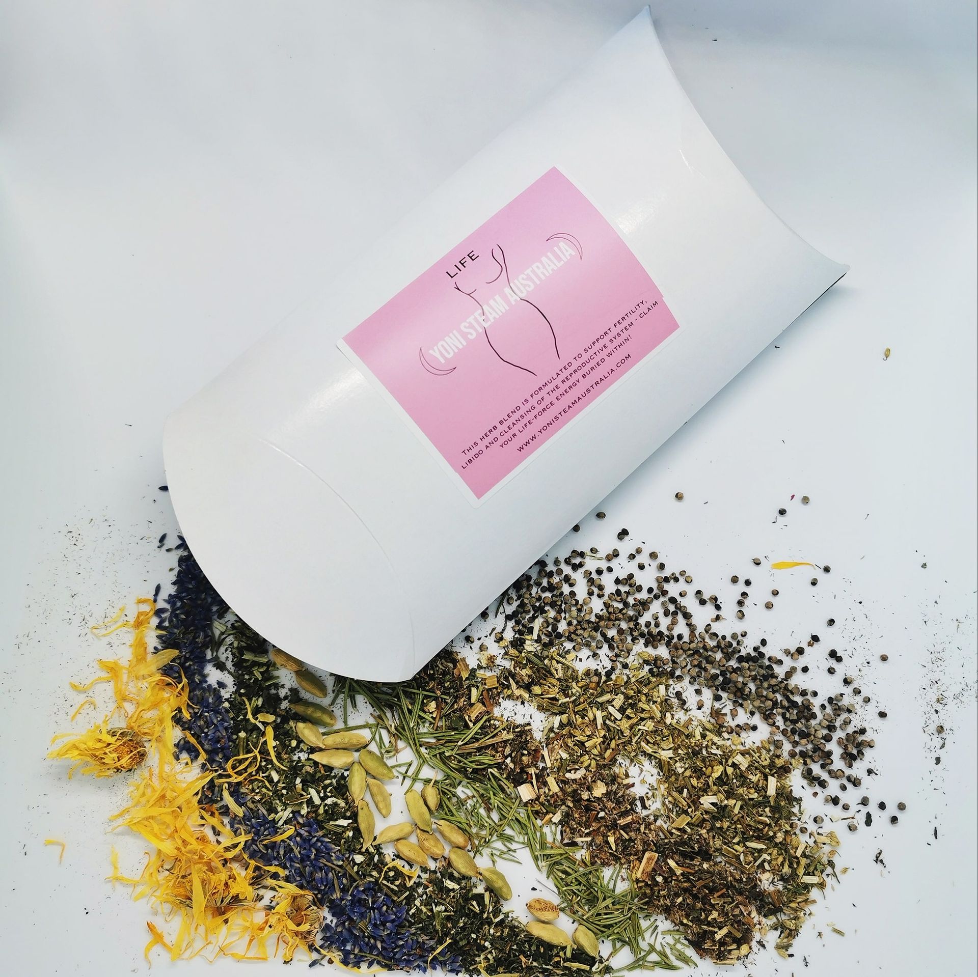 White bag of herbs with a pink label, spilling onto a white surface with dried flowers — Yoni Steam Australia in Gold Coast, QLD