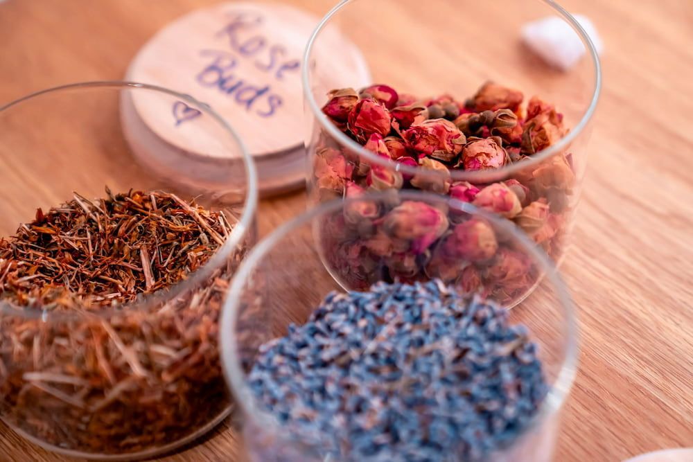 Four Glass Jars Filled With Different Types of Dried Herbs — Yoni Steam Australia in Gold Coast, QLD