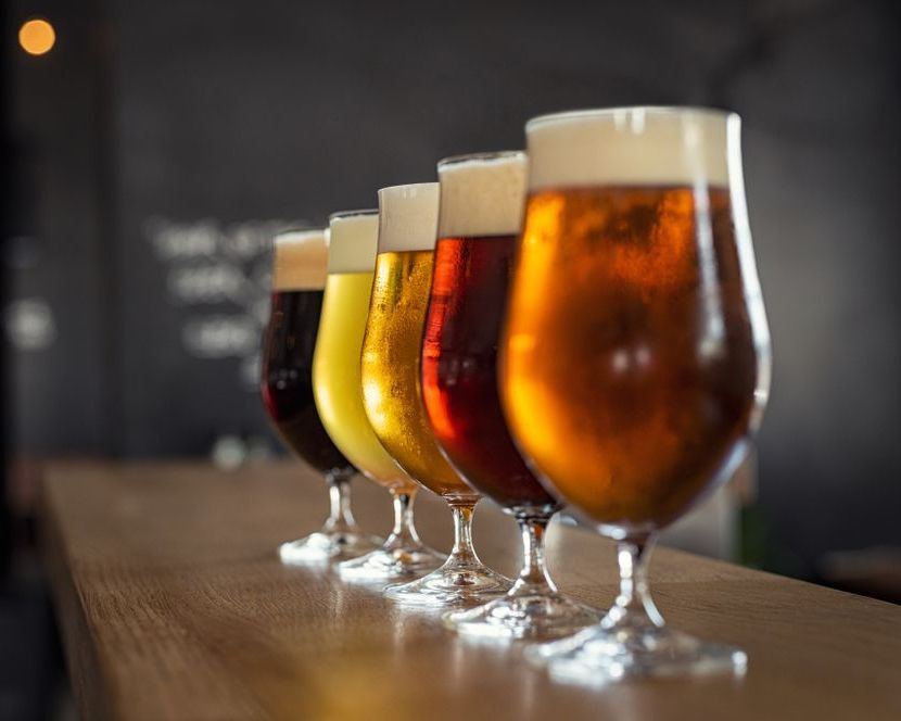 A Row Of Glasses Filled With Different Types Of Beer Are Lined Up On A Bar — Casa Portugal In South Hurstville, NSW