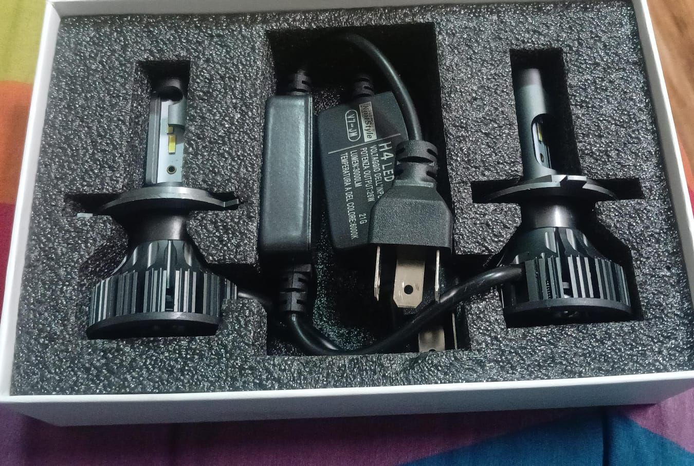 Dos bombillas LED para faros de coche en una caja con fuente de alimentación.