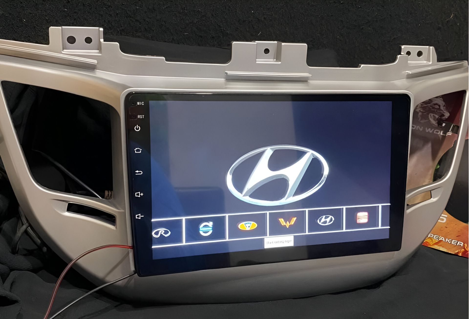 Salpicadero de coche con logotipo de Hyundai en pantalla táctil, detalles en color plata.