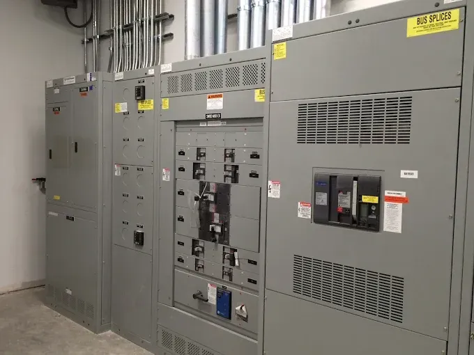 Electrical switchgear in an industrial setting, various gray cabinets with electrical components.