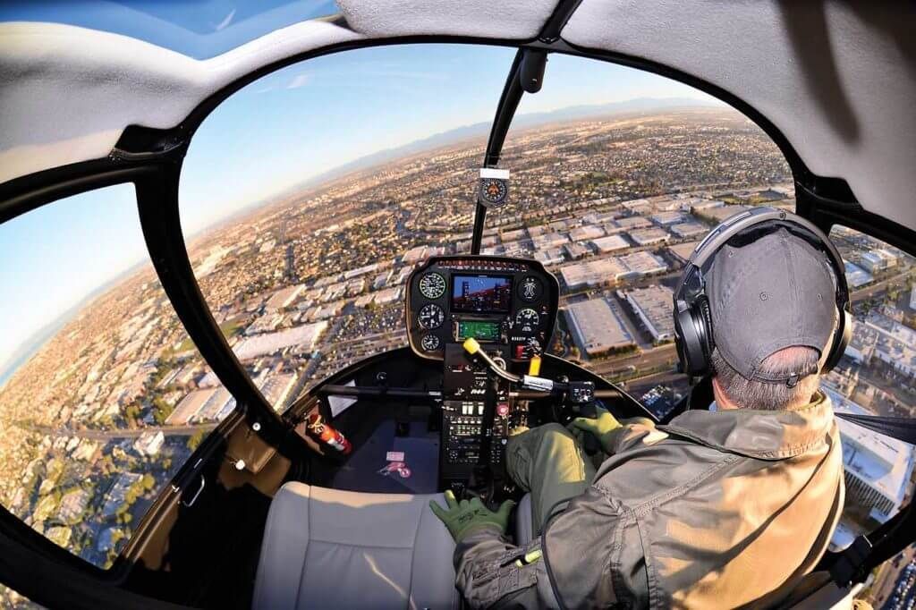 A man is flying a helicopter over a city