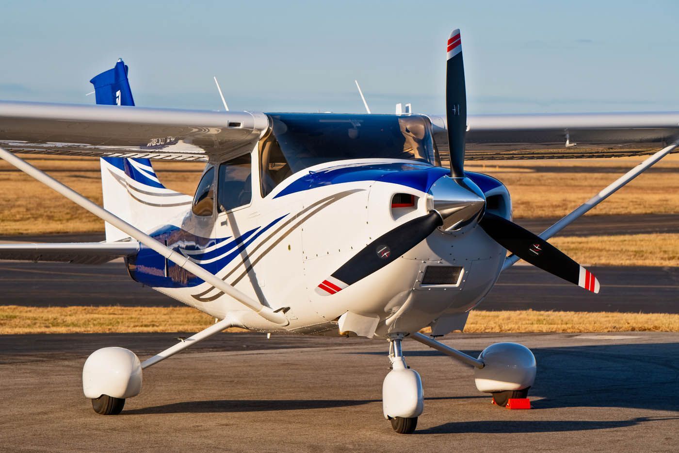 A small propeller plane is parked on a runway.