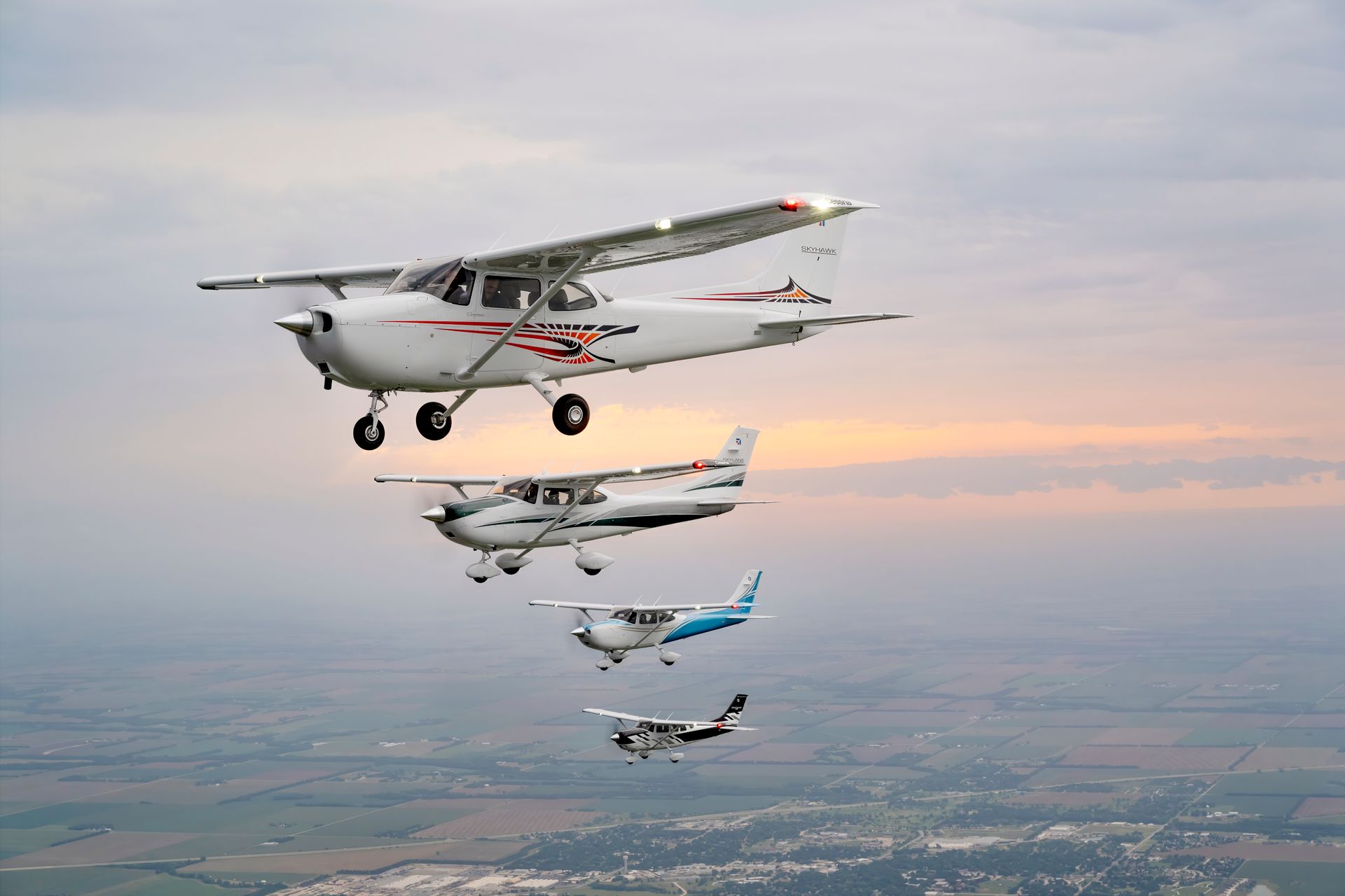 A group of small planes are flying in formation in the sky.