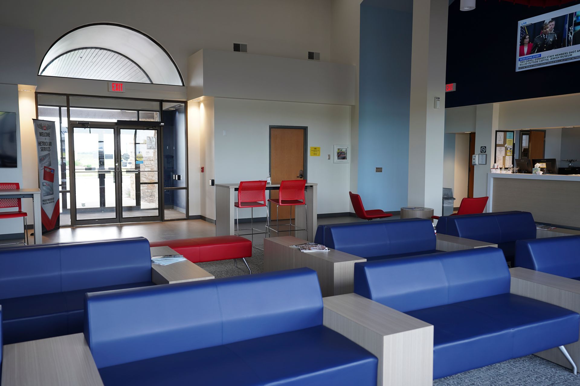 A waiting room with blue couches and red chairs