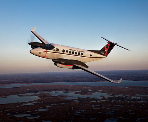 A small propeller plane is parked on a runway