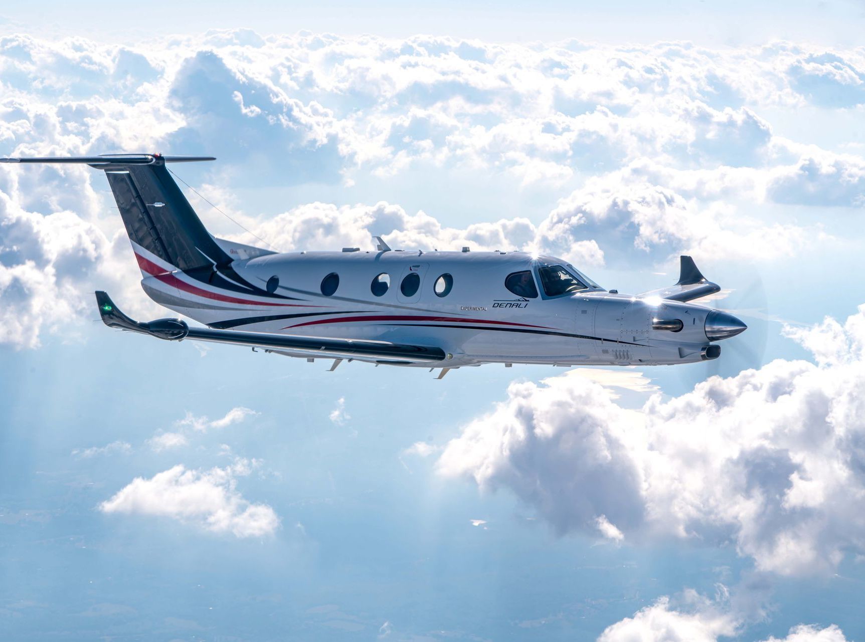 A small plane is flying through the clouds in the sky.
