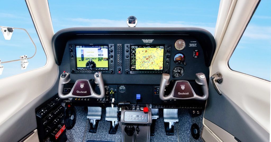 A cockpit of an airplane with three monitors on it