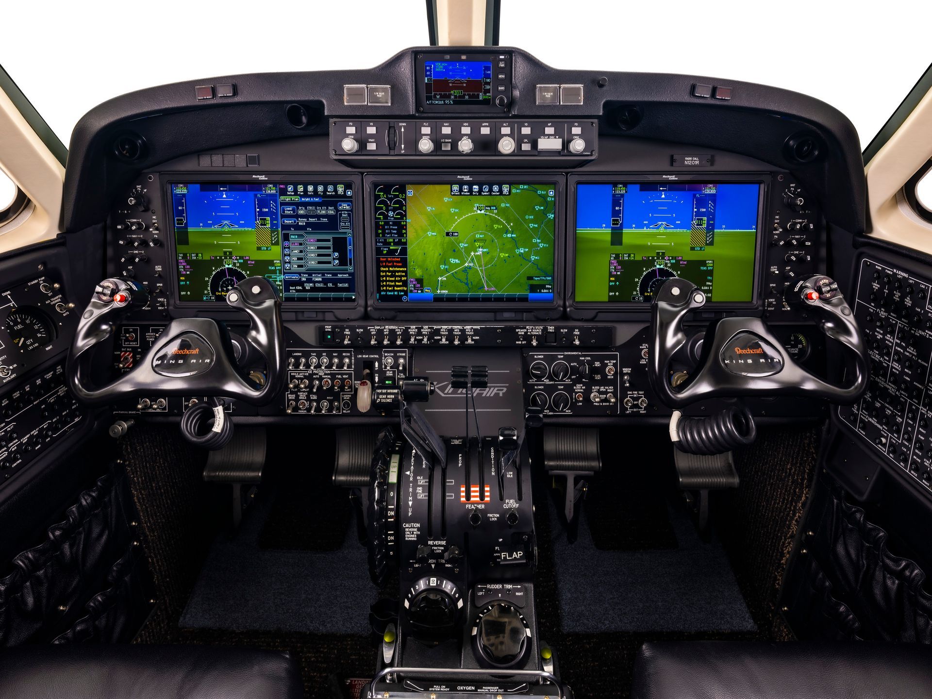 A cockpit of an airplane with three monitors on it