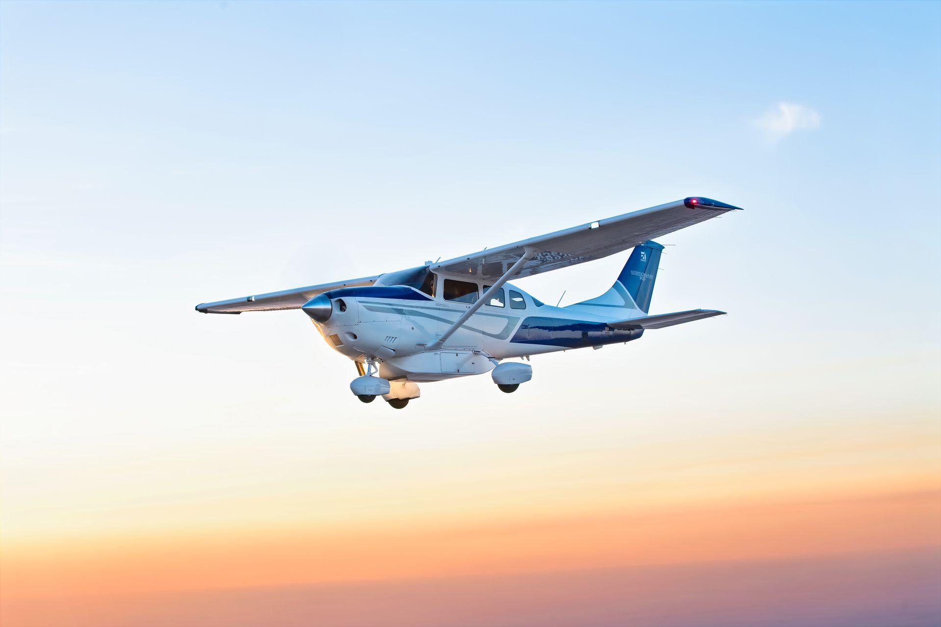 A small plane is flying in the sky at sunset.