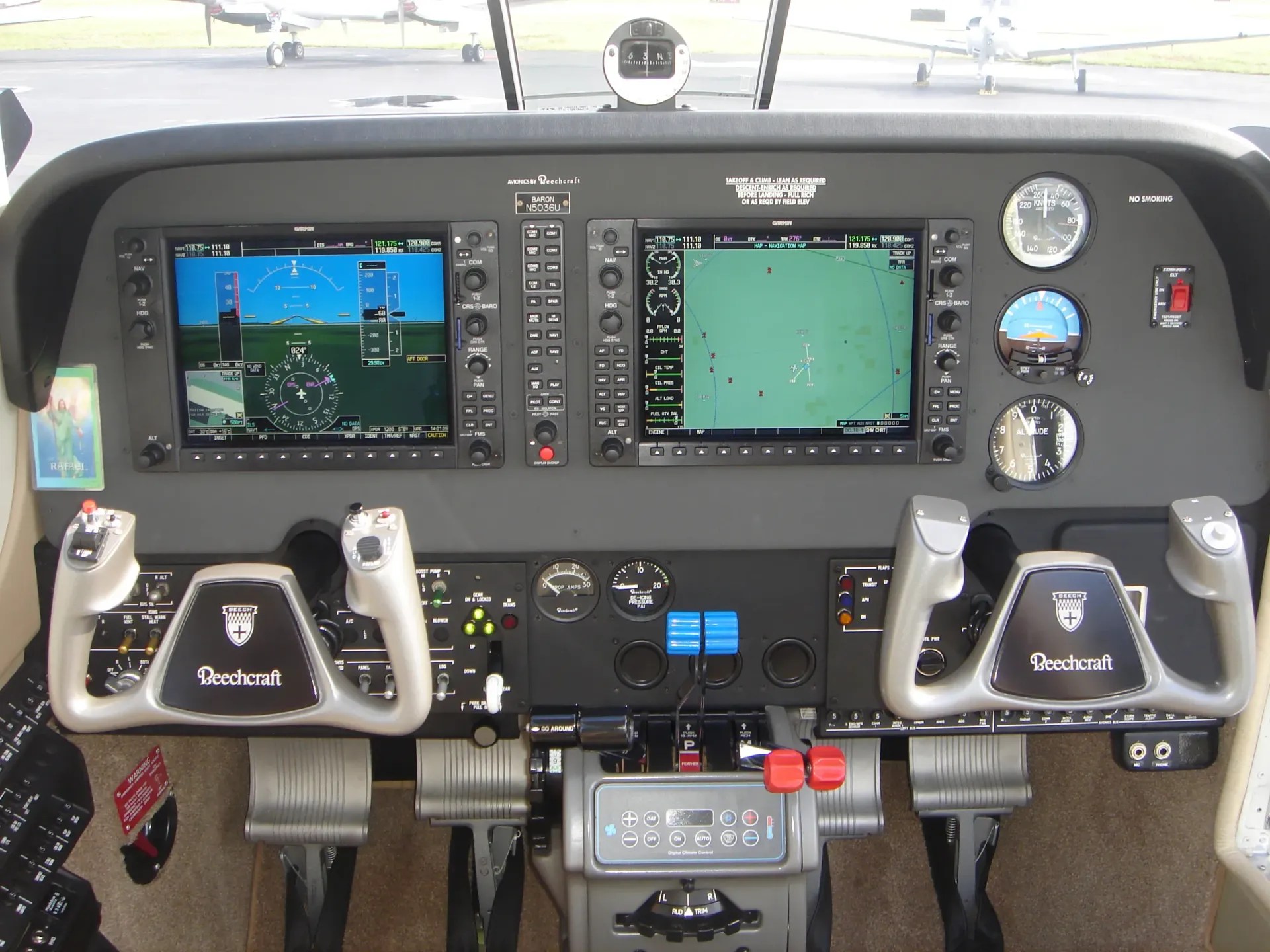 A cockpit of an airplane with three monitors on it