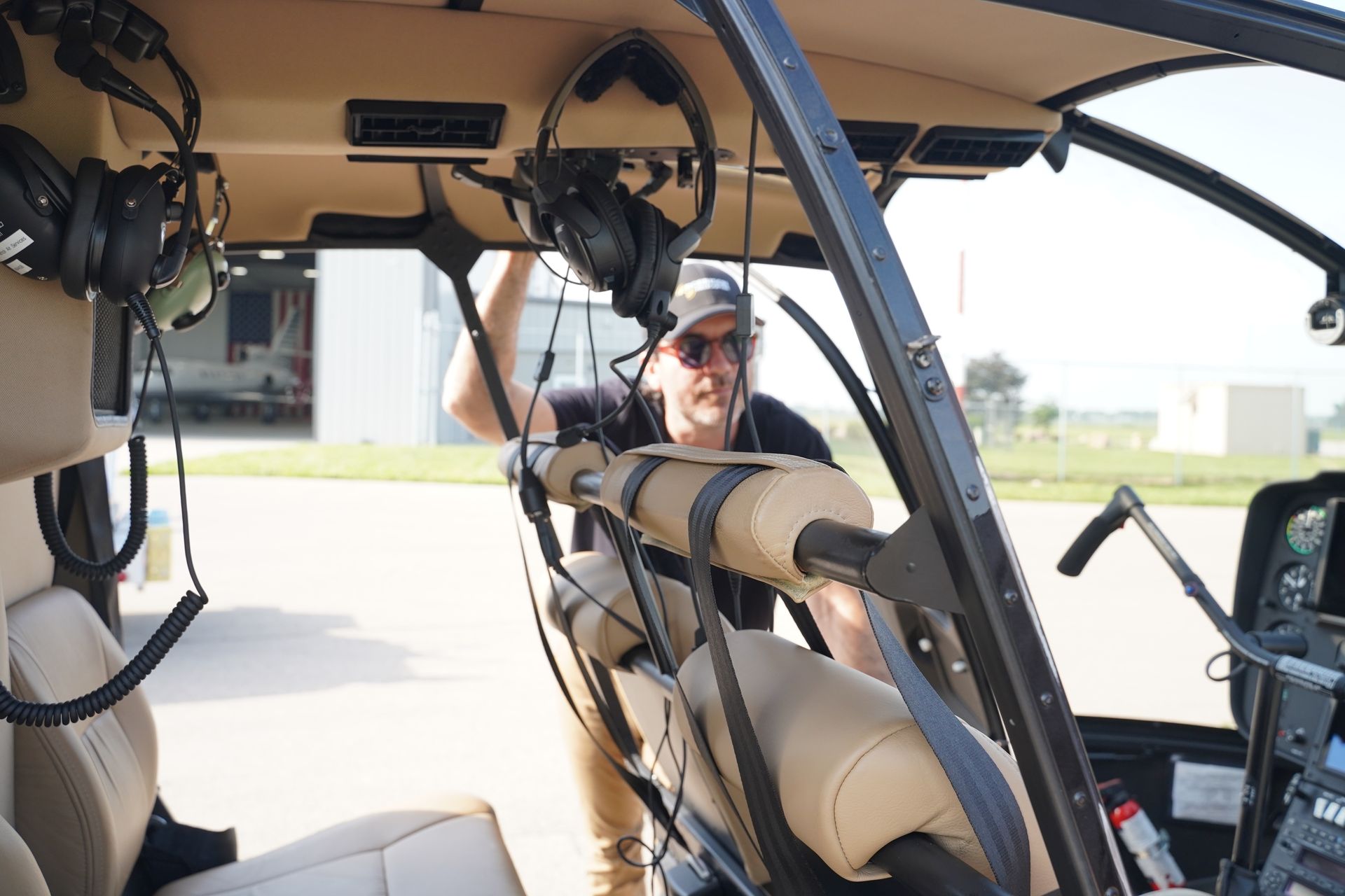 A man is sitting in the cockpit of a helicopter.