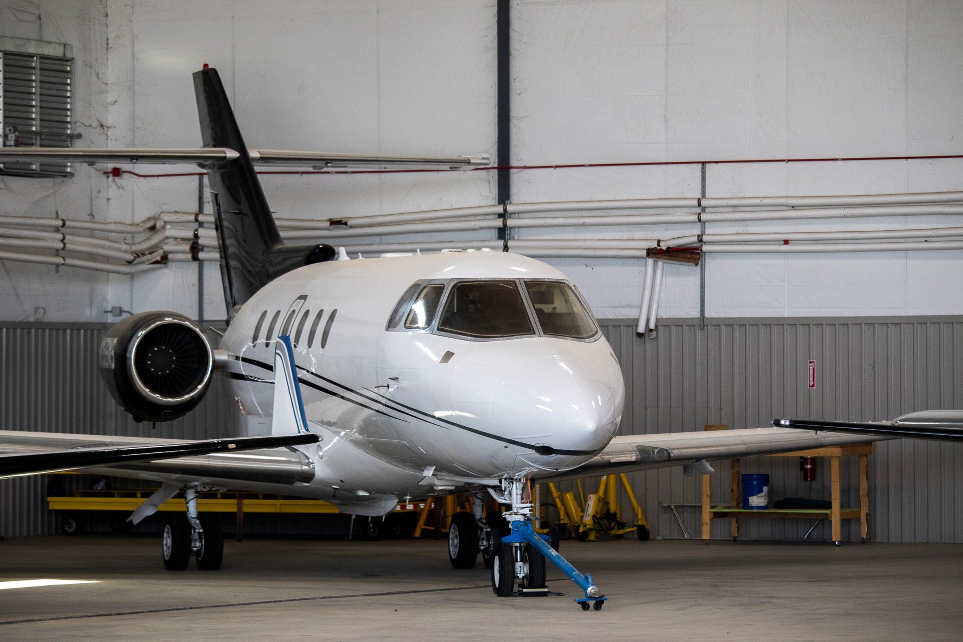 A private jet is parked inside of a hangar