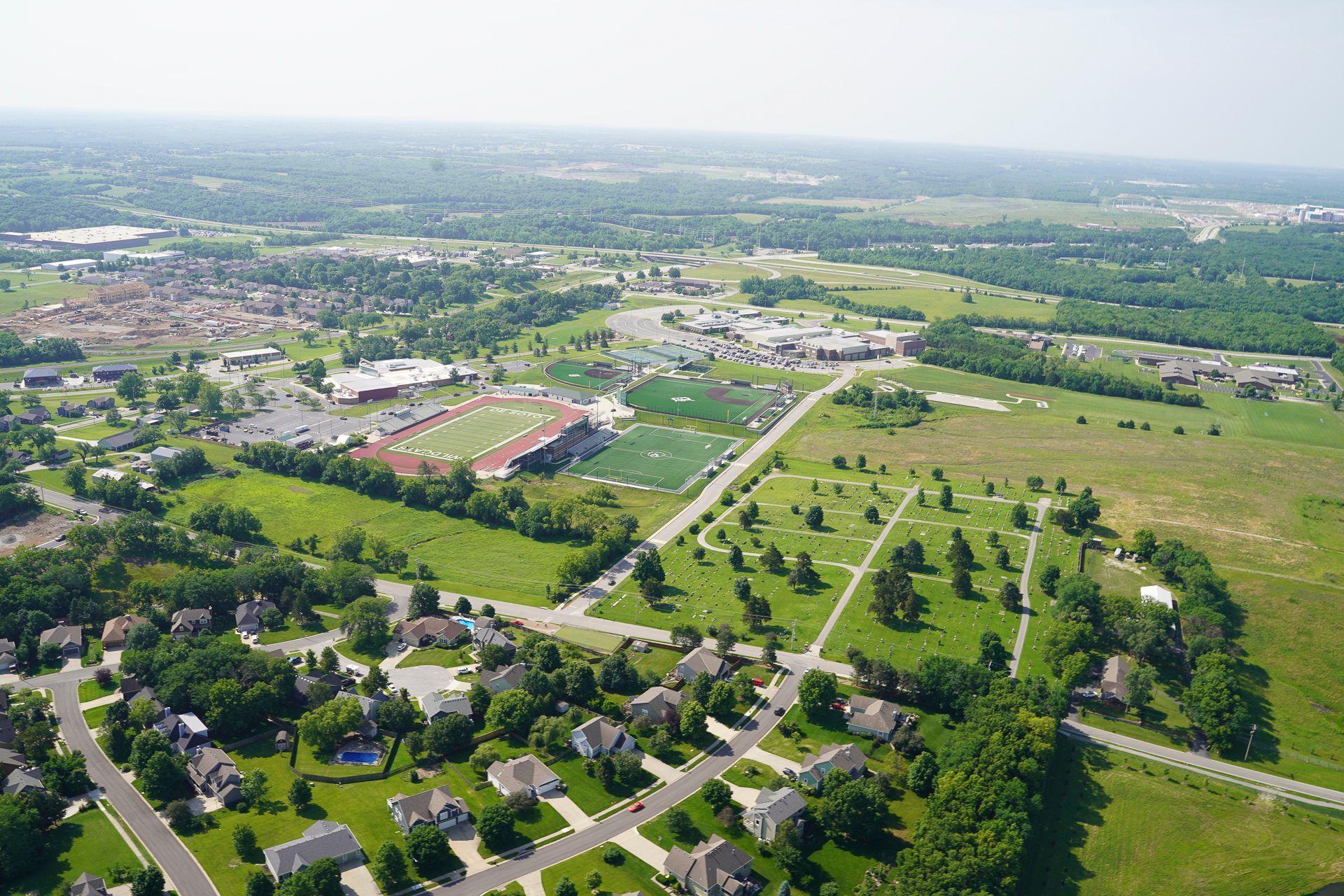 An aerial view of a residential area with lots of trees and grass.
