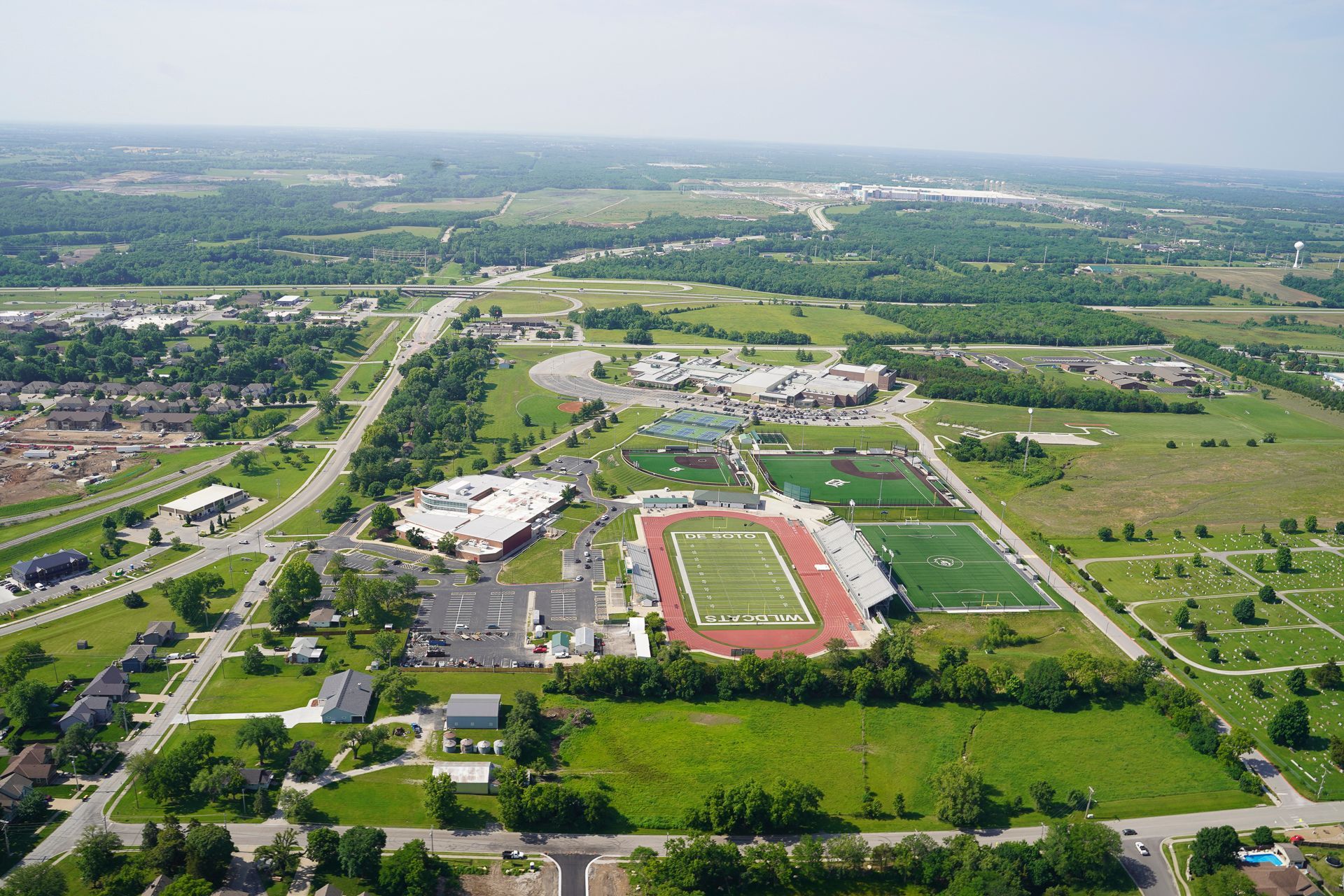 An aerial view of a city with a football field in the middle
