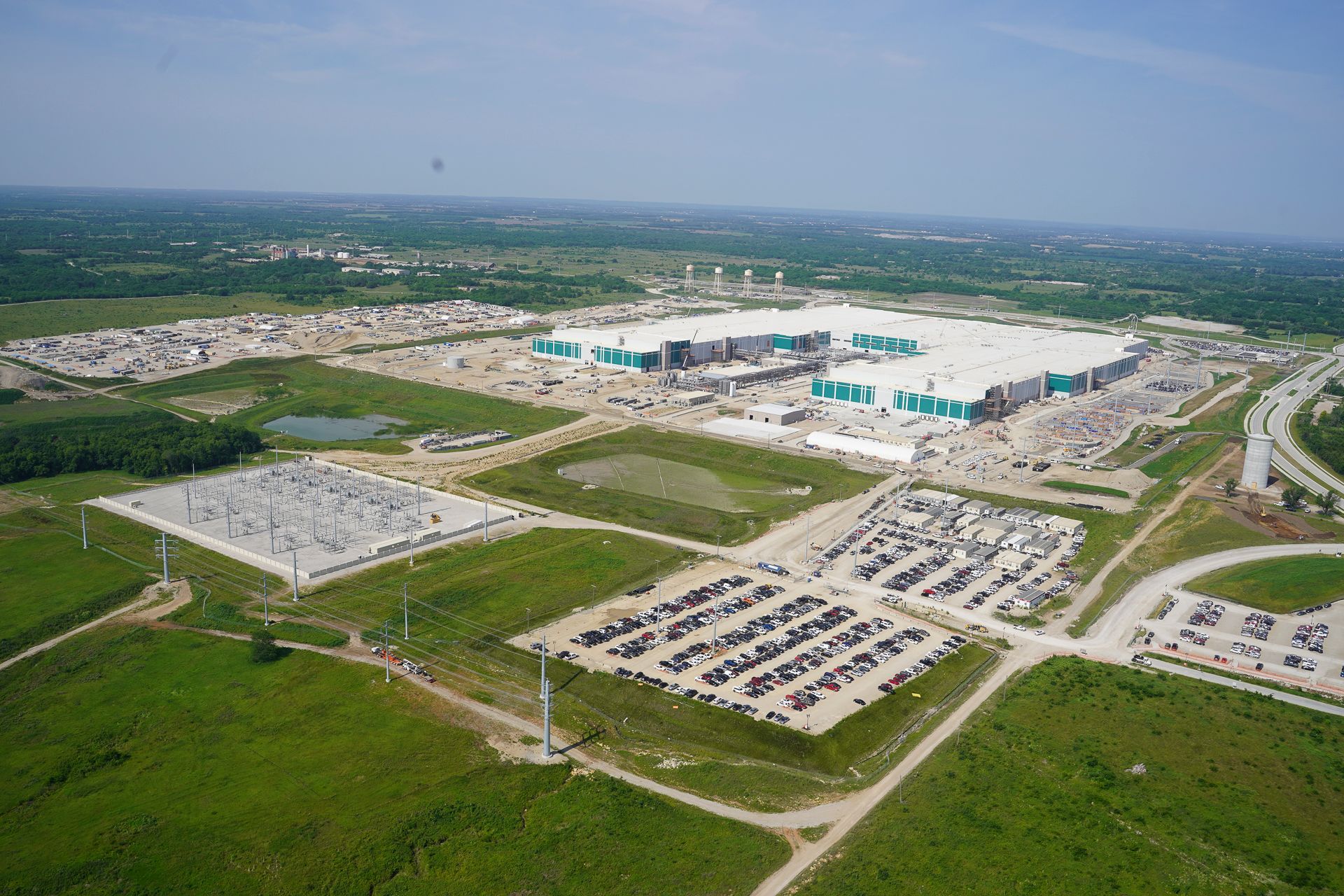 An aerial view of a large building with a lot of parking spaces in front of it.