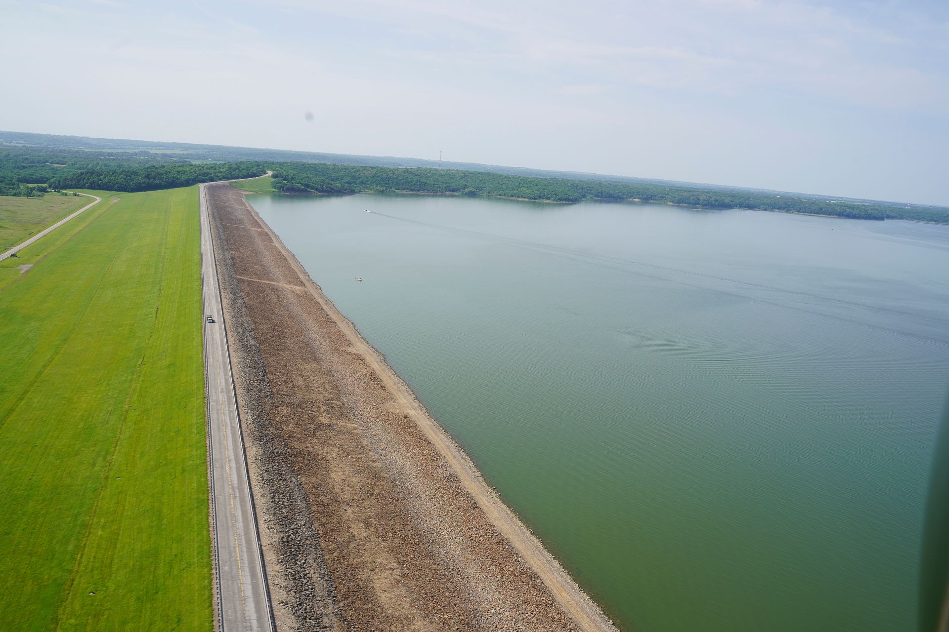 An aerial view of a large body of water surrounded by grass and trees.