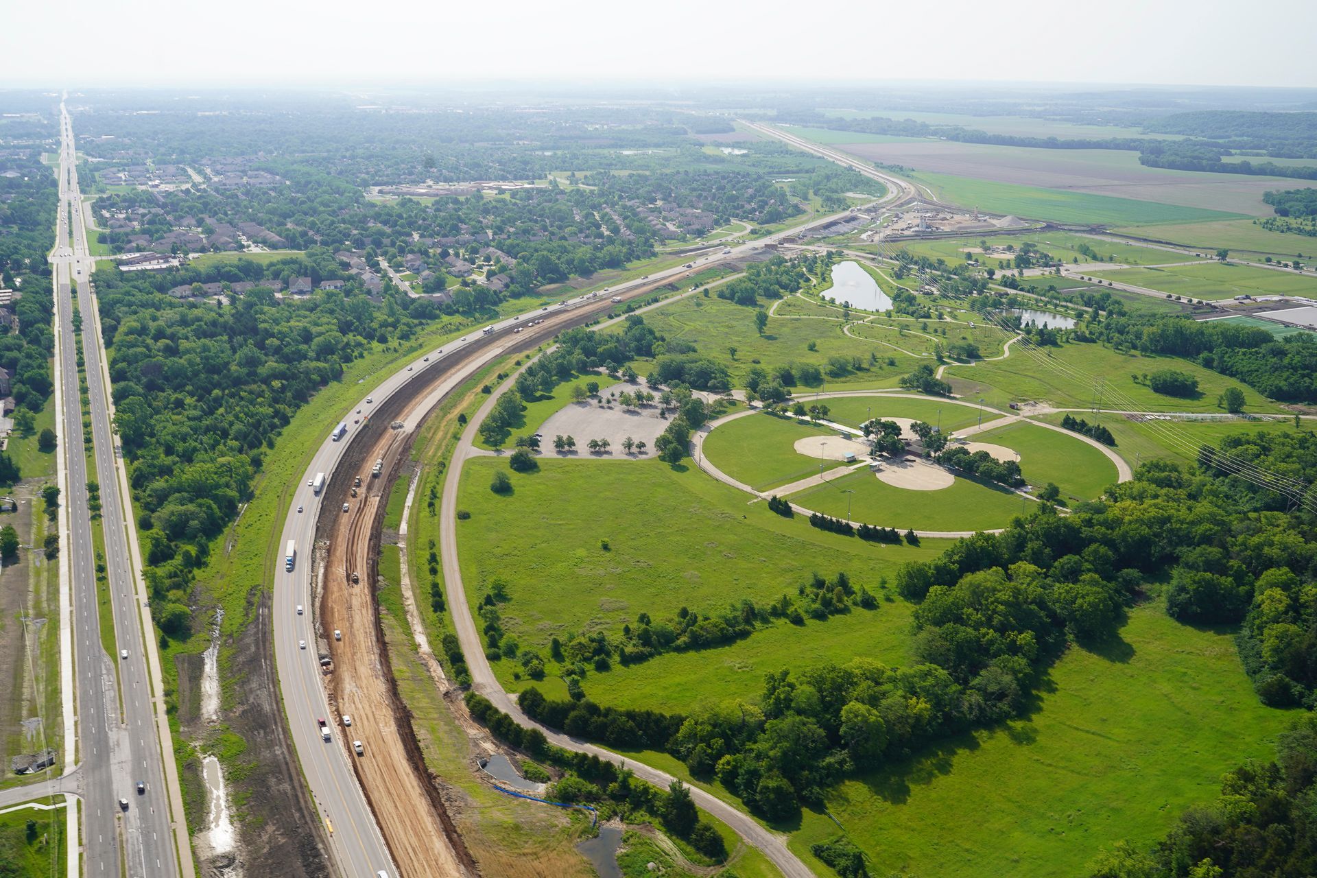 An aerial view of a highway and a baseball field.
