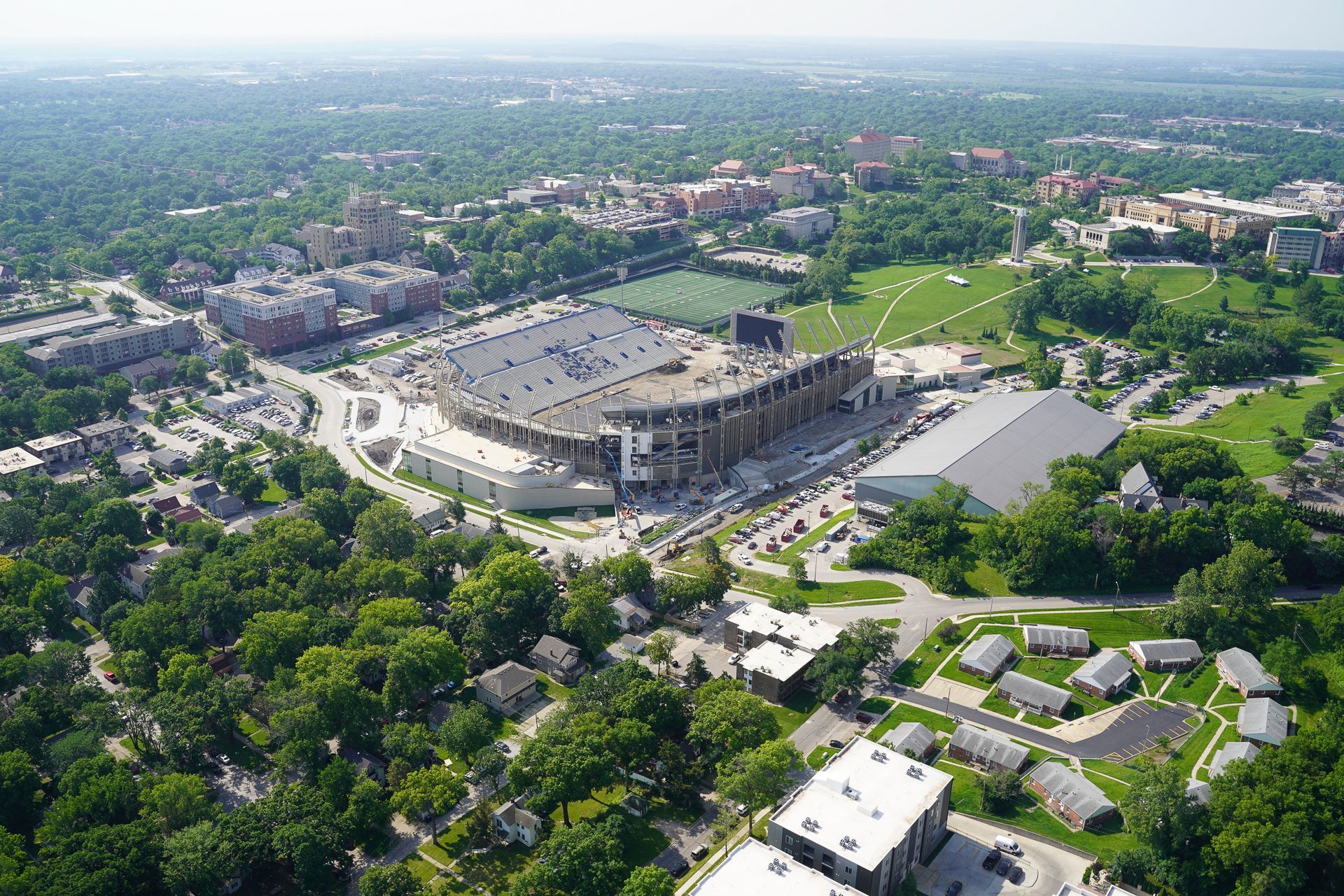An aerial view of a large stadium surrounded by trees and buildings.