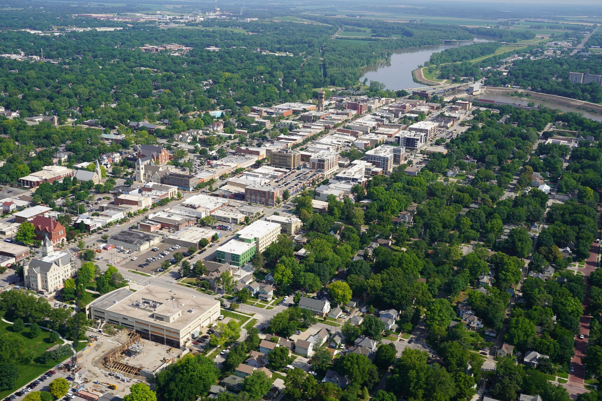 An aerial view of a city surrounded by trees and a river.