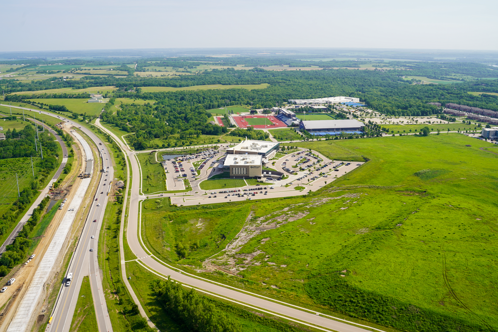 K 10 Highway Aerial Photography by Hetrick Air Service Lawrence with green grass, clear sky, and Rock Chalk Park