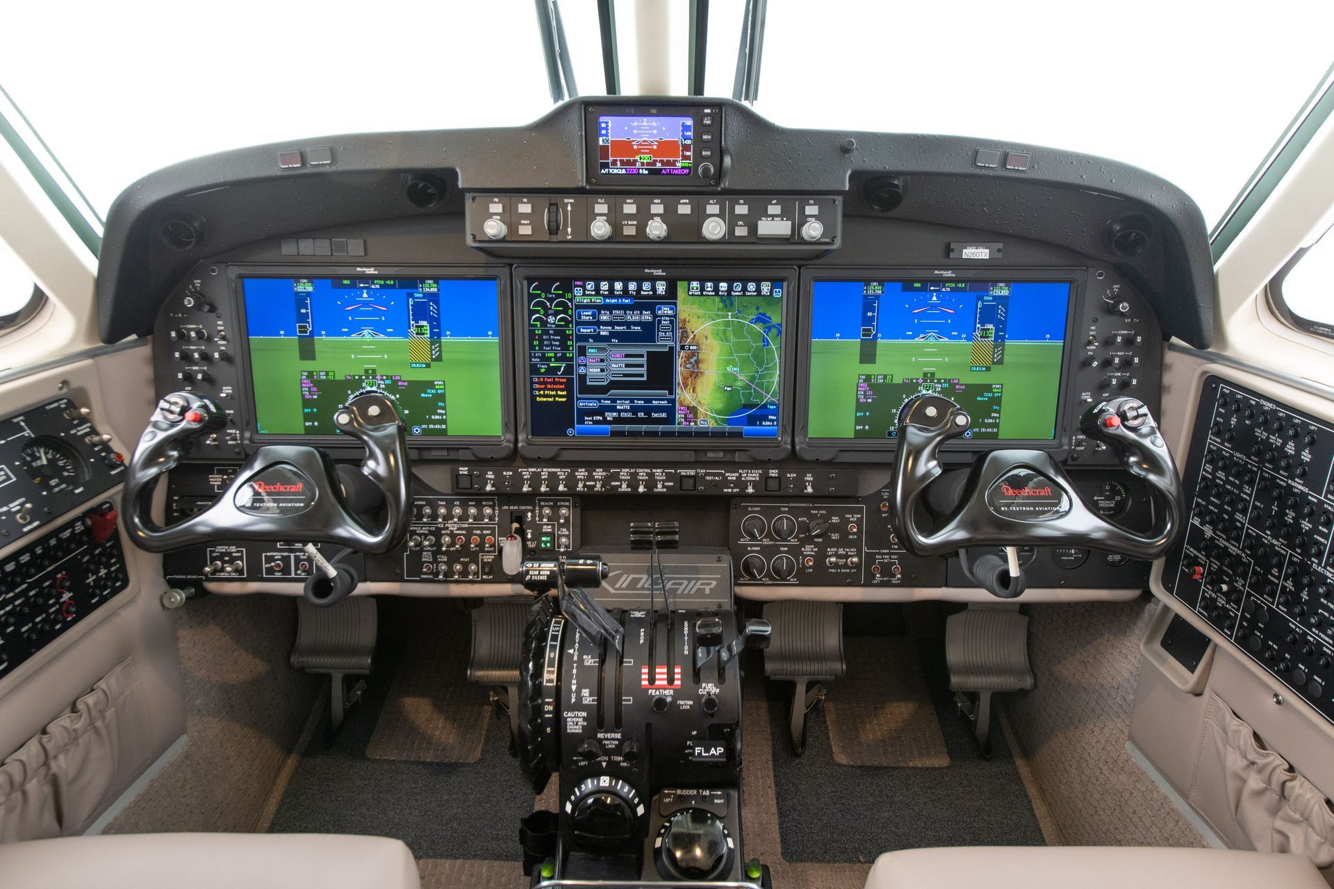 A cockpit of an airplane with three monitors on it