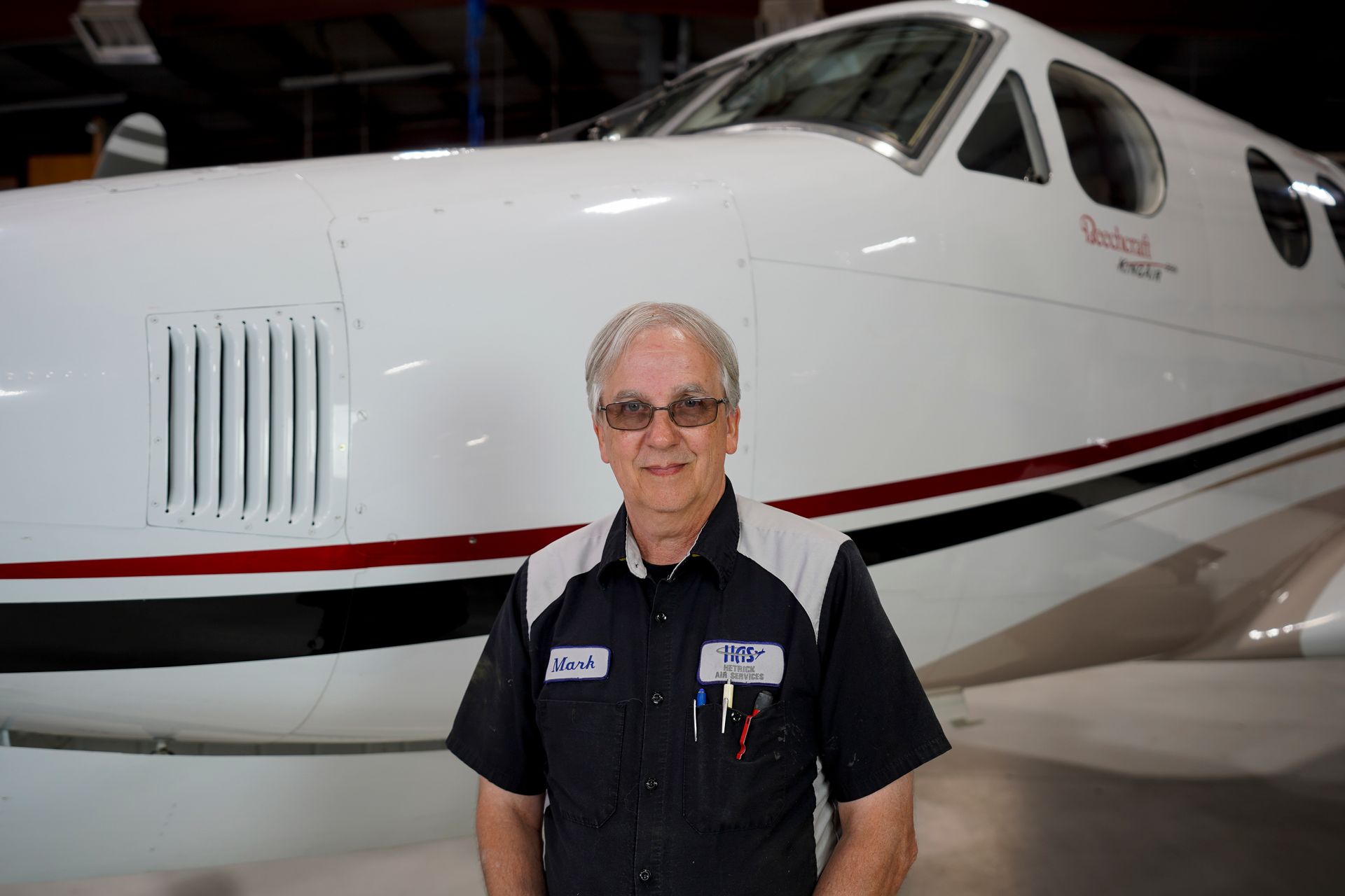 A man is standing in front of a small airplane.