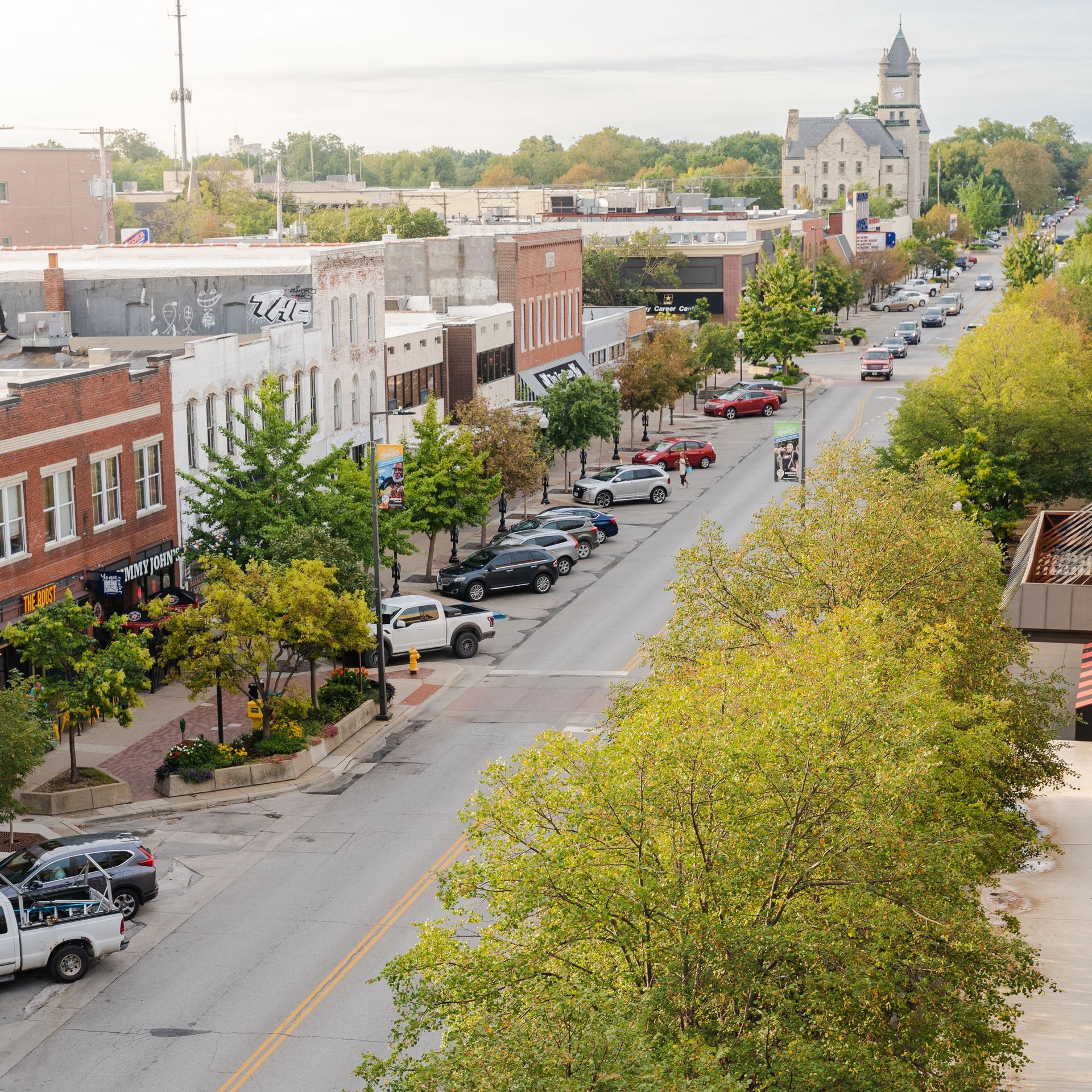 An aerial view of a city street with a clock tower in the background