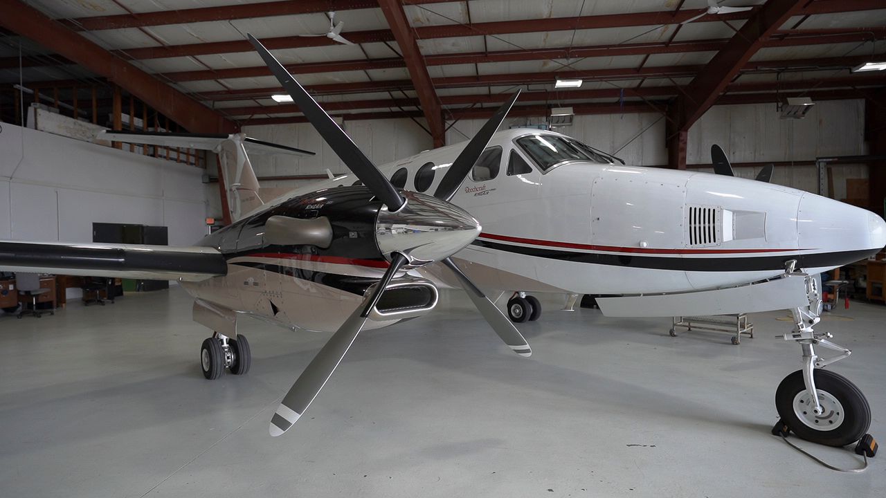 A small propeller plane is parked in a hangar.
