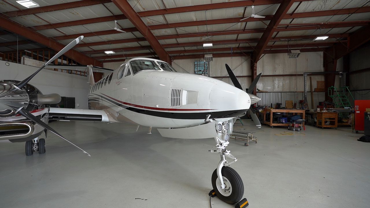 A small propeller plane is parked in a hangar.