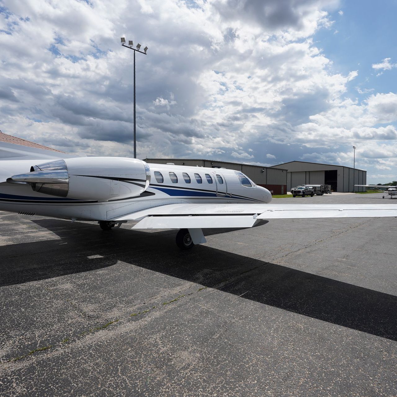 A small private jet is parked on the tarmac at an airport.