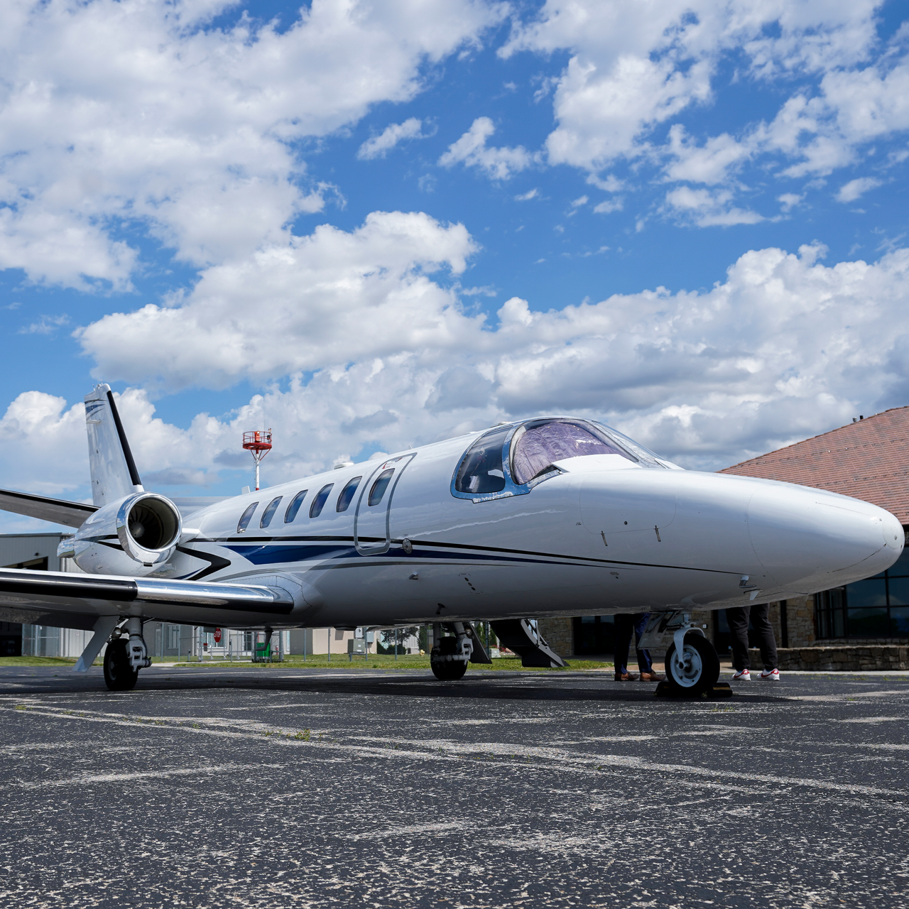 A small white airplane is parked on a runway.