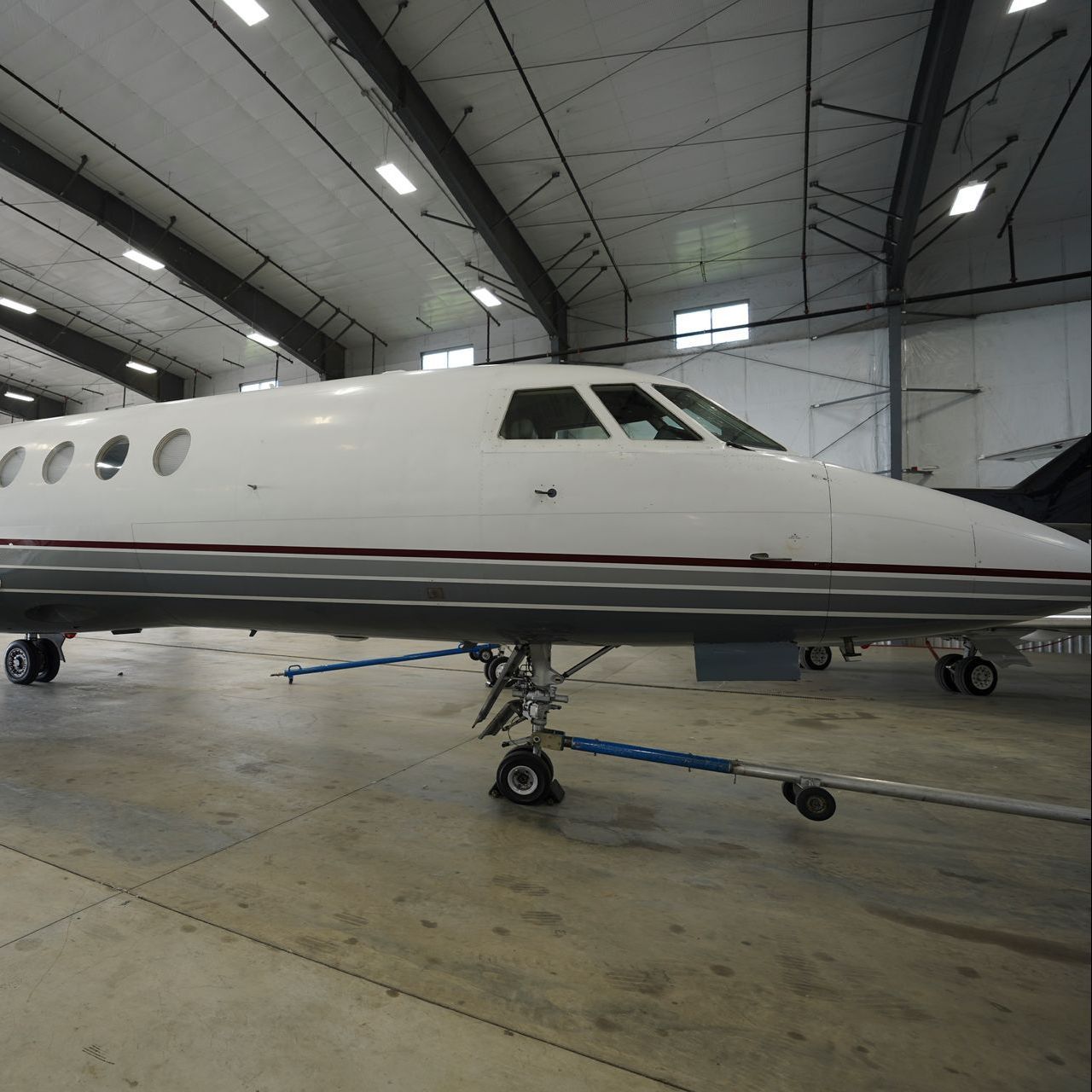 A private jet is parked inside of a hangar