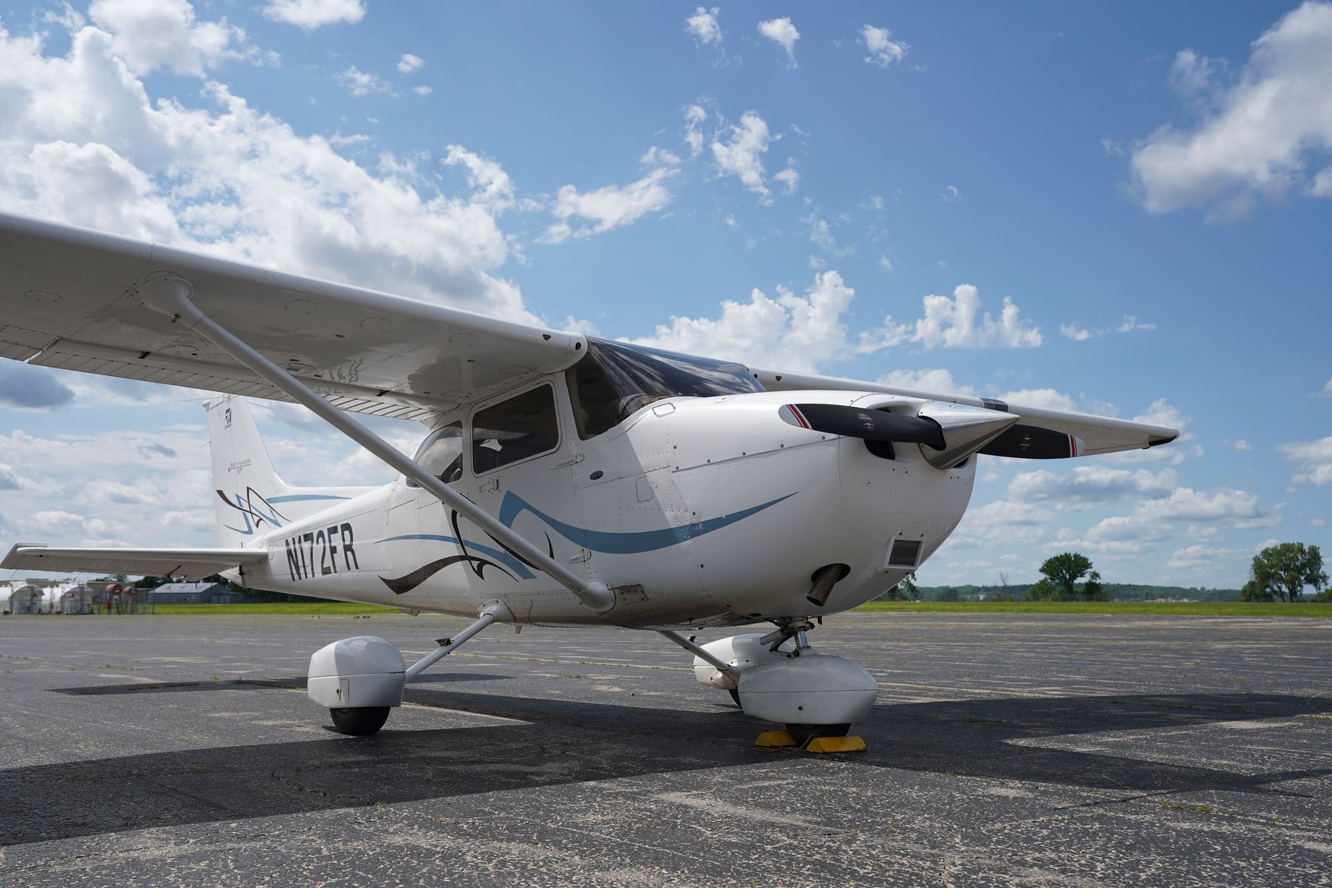 A small propeller plane is parked on a runway.