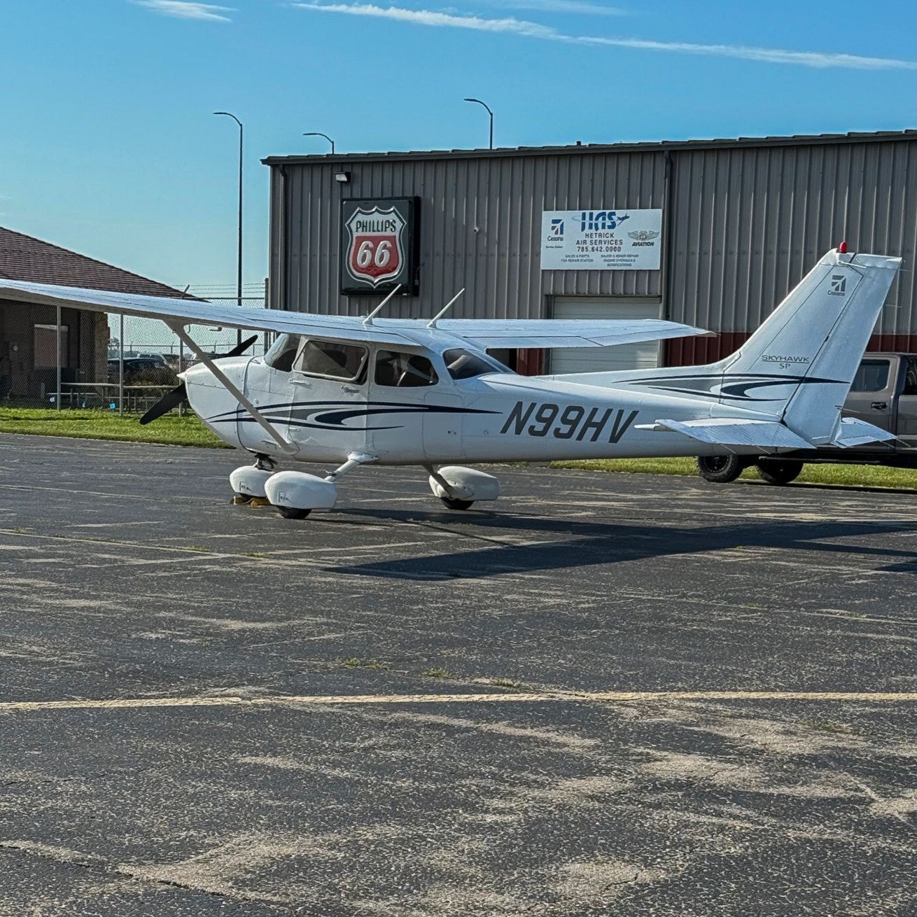 A small propeller plane is parked on a runway.