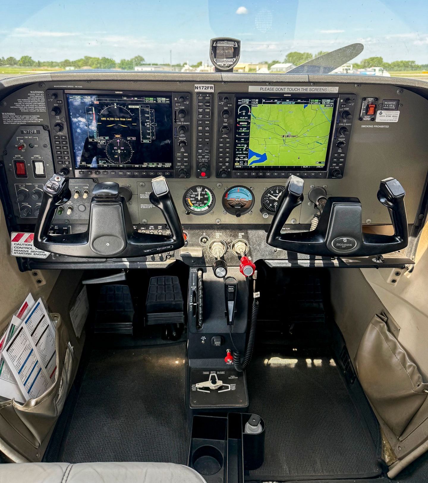 A cockpit of an airplane with a lot of monitors