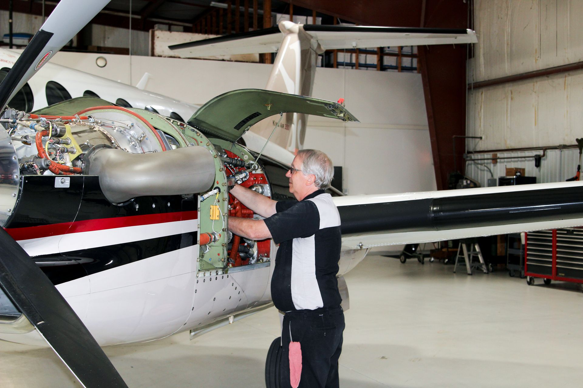 A man is working on an airplane in a hangar