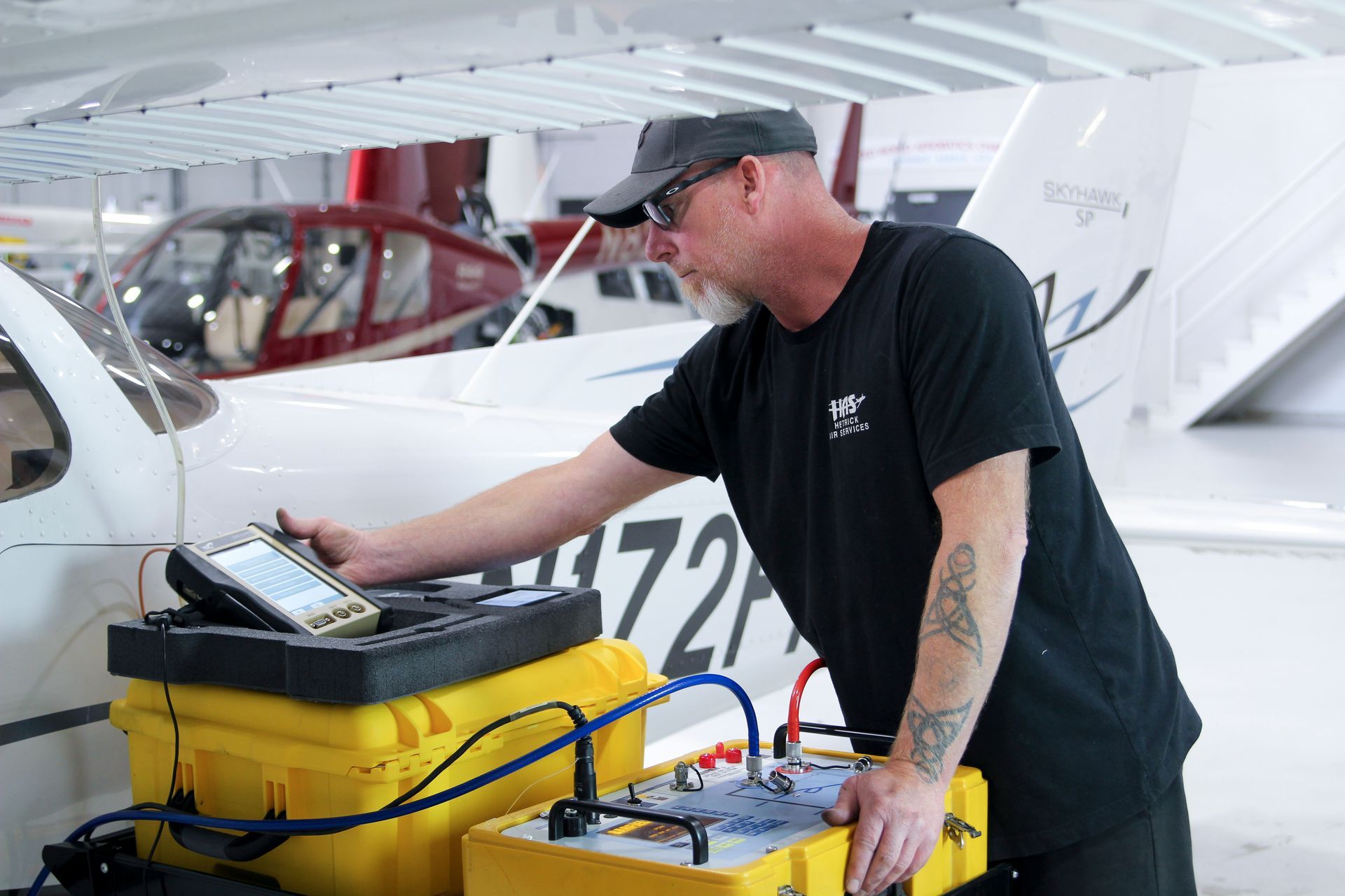 A man is working on an airplane in a hangar.