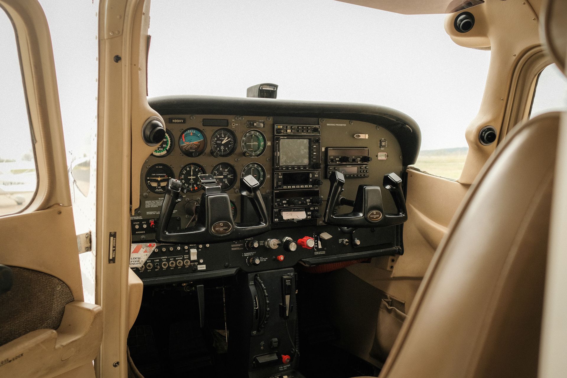 The cockpit of an airplane with a lot of monitors and controls.