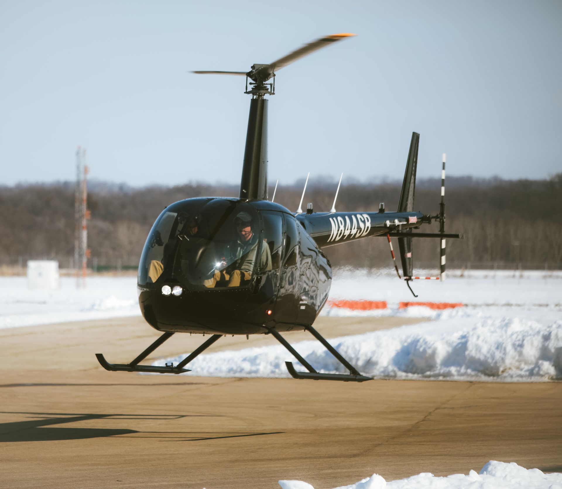 A small black helicopter with the letters xkl49 on the tail