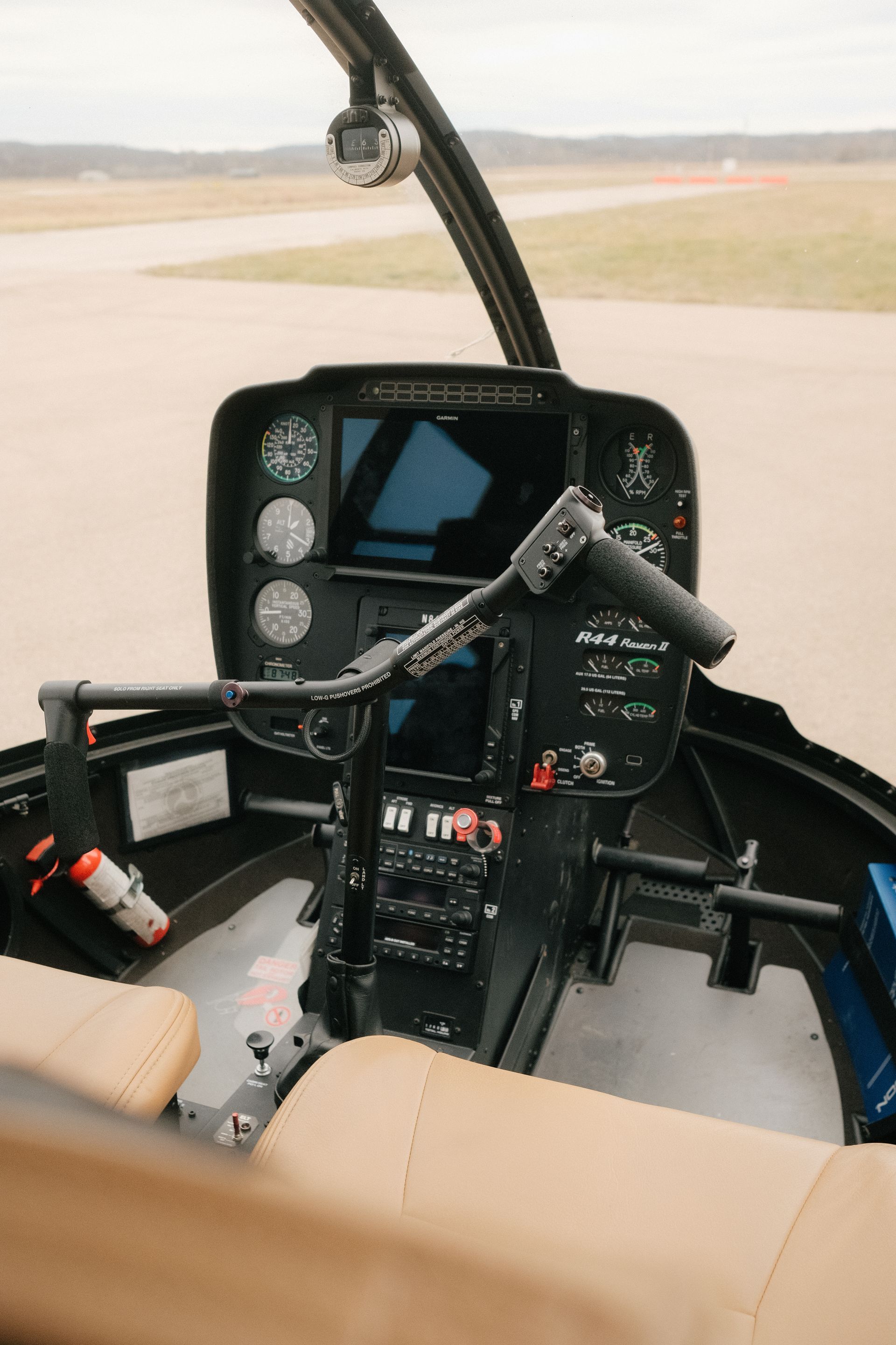 The cockpit of a small helicopter is shown.